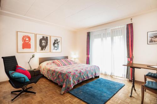 a bedroom with a bed and a desk and a chair at Appartements Hofquartier in Lucerne