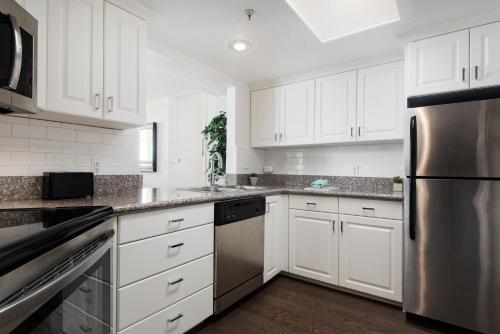 a kitchen with white cabinets and a stainless steel refrigerator at The Kimball at Temple Square in Salt Lake City