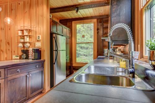a kitchen with a sink and a refrigerator at Chic log chalet with hot tub - Mont-Tremblant north side by Reserver.ca in Lac-Superieur