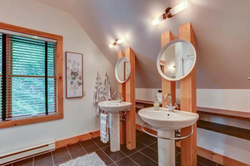 a bathroom with two sinks and a mirror at Chic log chalet with hot tub - Mont-Tremblant north side by Reserver.ca in Lac-Superieur