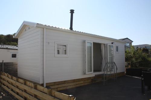 a tiny house with a porch and a patio at Chalet Charlee in IJmuiden