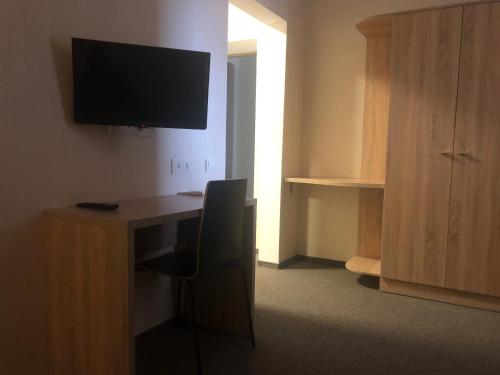 a room with a desk with a chair and a television at U Fedora in Oleksandriya