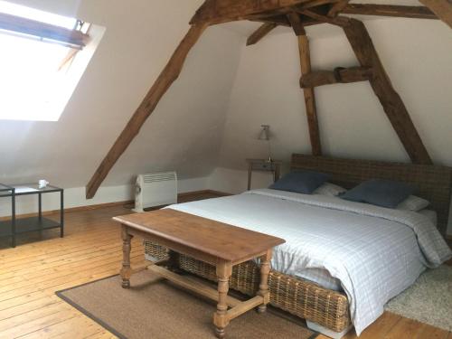 1 dormitorio con cama y mesa de madera en La Maison en Les Forges