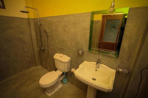 La salle de bains est pourvue de toilettes et d'un lavabo. dans l'établissement Snuggle Cottage, à Ella
