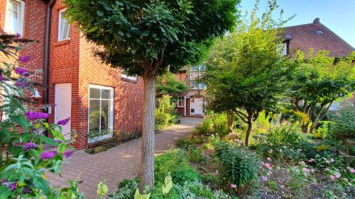 a garden in front of a brick building at Auenglück (inkl. THERMEplus) in Bad Bevensen