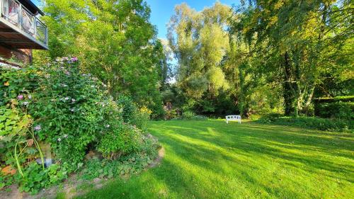 a yard with a green lawn with trees and a house at Auenglück (inkl. THERMEplus) in Bad Bevensen
