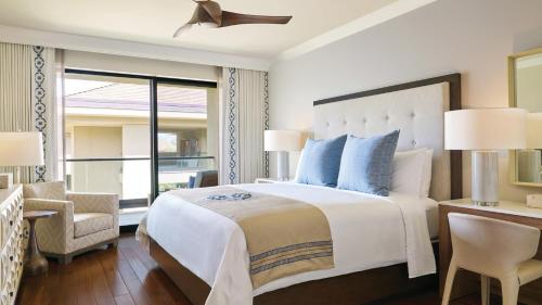 a bedroom with a large bed with blue pillows at Timbers Kauai Ocean Club & Residences in Lihue