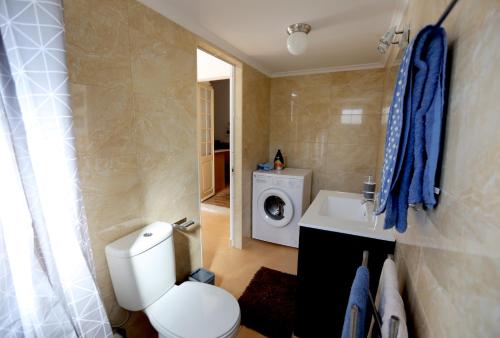 a bathroom with a toilet and a washing machine at Azeitão Village in Azeitao