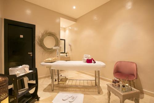 a bathroom with a sink and a red chair at Kech Boutique Hotel & Spa in Marrakech