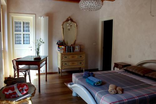 a bedroom with a bed and a desk and a mirror at Residenza Tre Corone in Vinadio