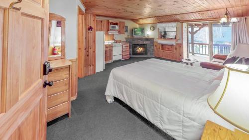 Rough Cut Lodge في Gaines: غرفة نوم بسرير كبير ومدفأة