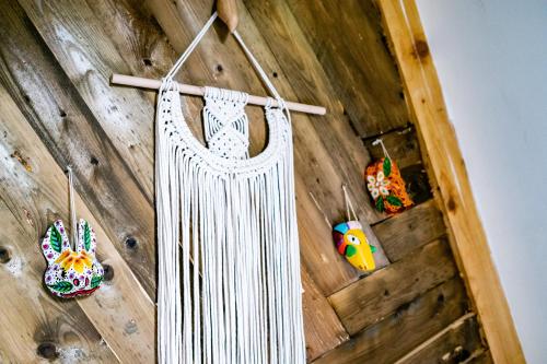 a white curtain hanging on a wooden wall with toys at Duende Hotel in Lagodekhi