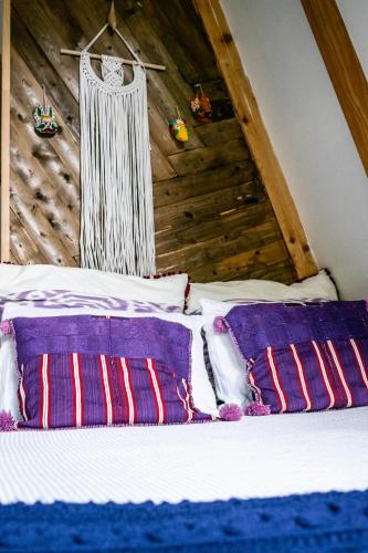 a bed with purple and white pillows in a room at Duende Hotel in Lagodekhi