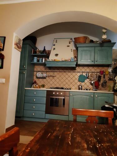 a kitchen with green cabinets and a table in it at B&B La Casa di Alice in Foligno