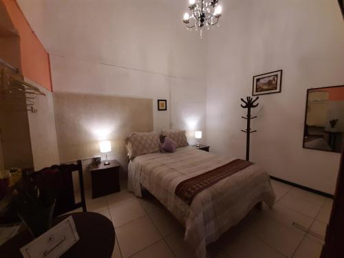 a bedroom with a bed and a chandelier at Casona de Sillar in Arequipa