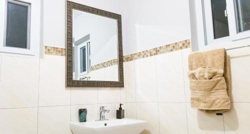 a white bathroom with a sink and a mirror at Casa Tamar Guest Apartment in Kingston