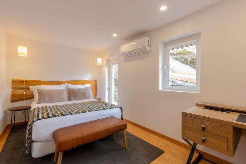 1 dormitorio con cama, ventana y TV en YOUROPO - Cosy en Oporto