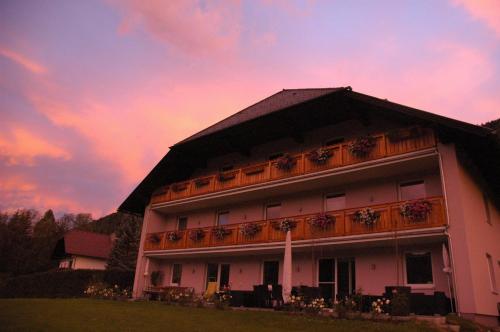 a building with a balcony with a sunset in the background at Appartement Haus Moser in Sankt Michael im Lungau