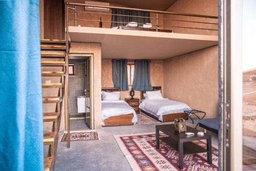 een slaapkamer met 2 bedden en een stapelbed bij Zeina Desert Lodge in Wadi Rum
