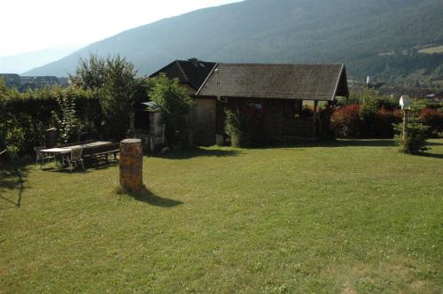 a house in a field with a picnic table at Appartement Haus Moser in Sankt Michael im Lungau