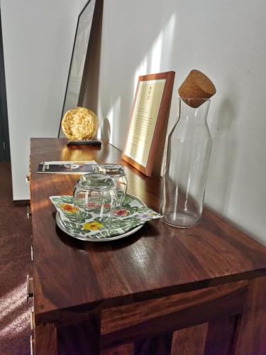 a table with a glass bottle and a plate on it at Malkia Penzion in Orechová Potôň