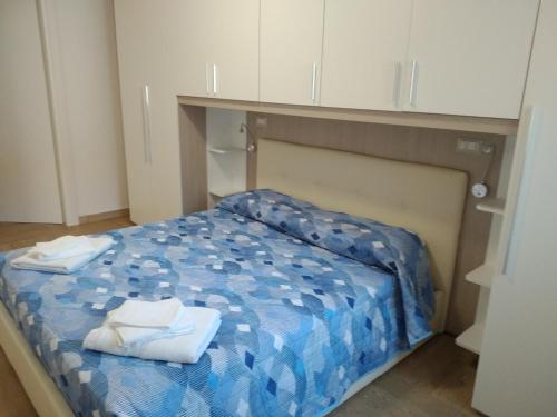 Habitación pequeña con cama y toallas. en ORISTANO CAMERA BLU max 2 pers, BAGNO E USO CUCINA, en Oristano