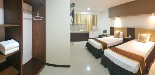 a hotel room with two beds and a bathroom at North Tourist Inn in Bacolod
