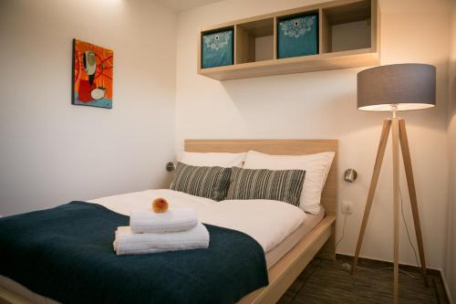 a bedroom with a bed with towels on it at Hišice Čarna - Houses Čarna in Puconci