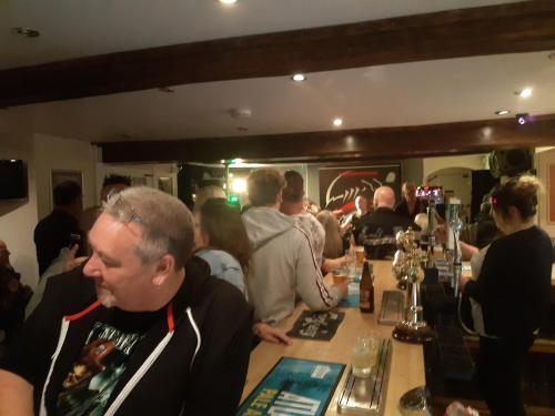 un grupo de personas sentadas en un bar en The Rampant Horse Public House, en Fakenham