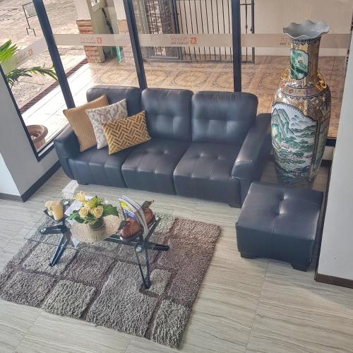 a living room with a leather couch and a table at North Tourist Inn in Bacolod