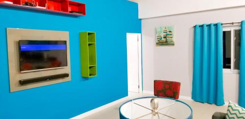 a living room with a table and a blue wall at Casa Tamar Guest Apartment in Kingston