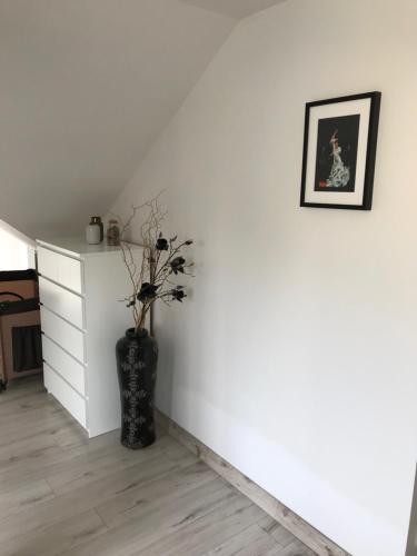a room with a vase with a plant on a wall at Apartmán na náměstí in Kašperské Hory