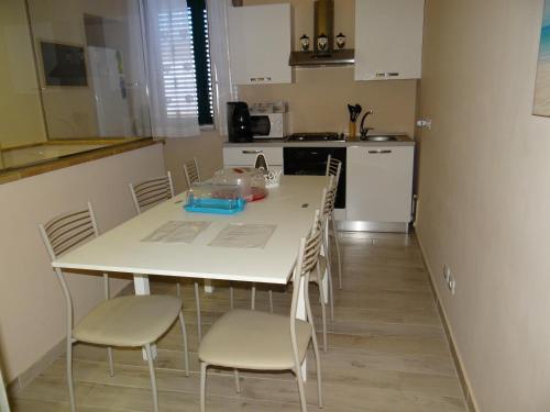 cocina con mesa blanca y sillas en una habitación en Monte Palace Palermo, en Palermo