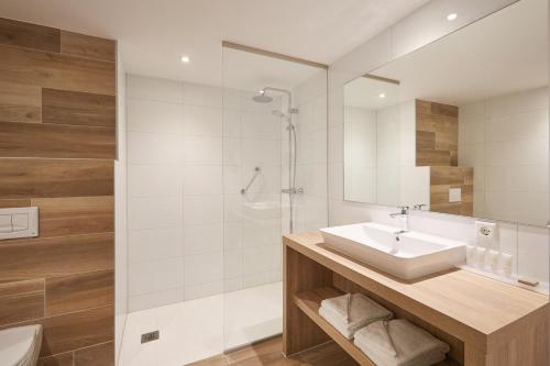 een badkamer met een wastafel en een douche bij Van der Valk Hotel Leusden - Amersfoort in Leusden