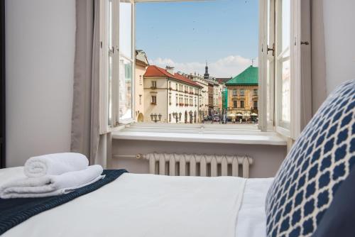 Schlafzimmer mit einem Bett und Stadtblick in der Unterkunft Square Apartment by LoftAffair in Krakau