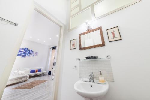 W białej łazience znajduje się umywalka i lustro. w obiekcie ATLANTA apartment is in the heart of Budapest w Budapeszcie