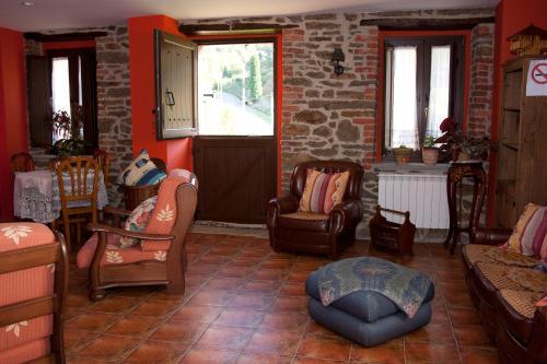a living room with chairs and a brick wall at Casa La Escuela in Tuilla