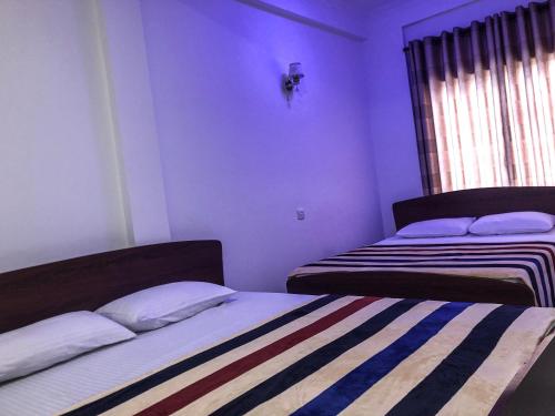 a bedroom with two beds and a window at Gimhana Guest House in Nuwara Eliya