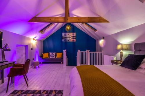 a bedroom with purple lighting and a bed and a desk at Rainbow House - Entire Place in Lutterworth