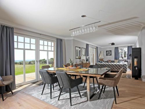a dining room and living room with a table and chairs at Strandhaus 7 "Ostsee" F663 mit Meerblick, Sauna, Kamin in Lobbe