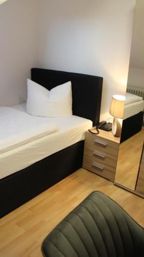 a small bedroom with a bed and a mirror at Hotel Glas Schwarzwald in Fluorn