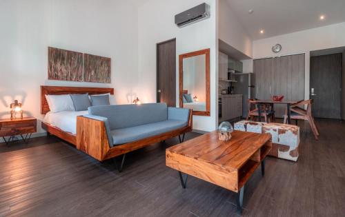 a bedroom with a bed and a couch and a table at BEE Suites Santa Ana in Santa Ana