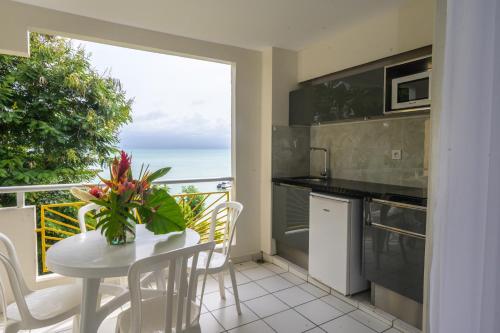 a kitchen with a table and a view of the ocean at Canella Beach Hotel in Le Gosier