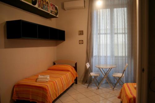 1 dormitorio con cama, mesa y ventana en Diana e Atteone, en Caserta