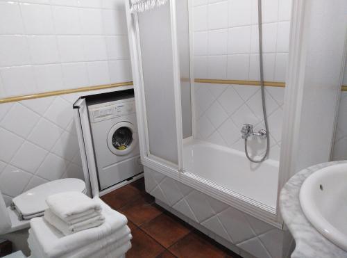 een badkamer met een douche en een wasmachine bij Casa Rural El Tejo in Arroyo Frio