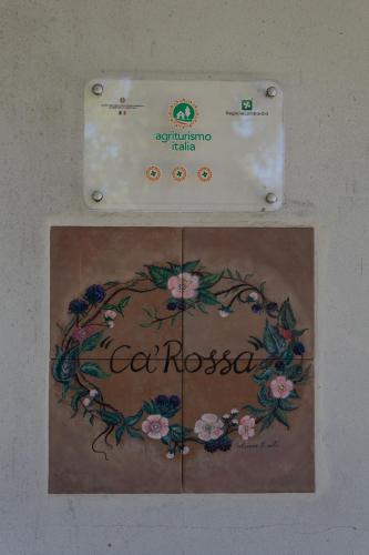a sign with a flower design on a wall at Agriturismo Cà Rossa in Pegognaga