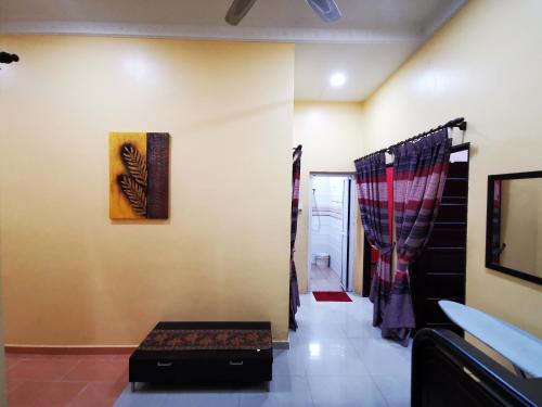 a room with a hallway with a table and a painting on the wall at Amera Homestay in Cukai