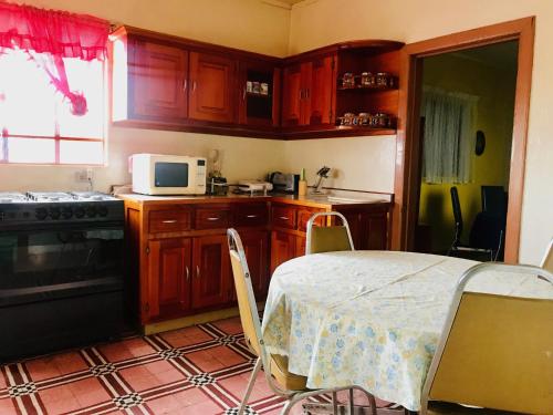 a small kitchen with a table and a microwave at Casa Afif in Tlatlauquitepec