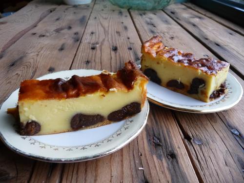 two slices of cake on plates on a wooden table at Chambre d'hôtes Suite 53m2 ou Caravane vintage avec cuisine et salle de bains privées, B&B 53m2 Suite or Vintage caravan with private kitchen and bathroom in Pleumeur-Gautier