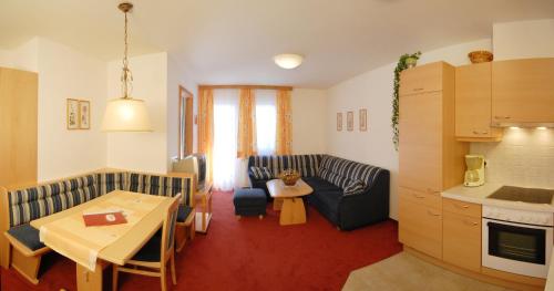 eine Küche und ein Wohnzimmer mit einem Sofa und einem Tisch in der Unterkunft Landhotel Kielhuberhof in Ramsau am Dachstein